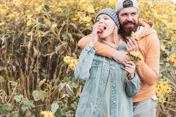 Höst utomhus porträtt av vacker lycklig flicka och skäggiga man går i Park eller skog. Mode höst porträtt kvinna och man med gula lönn löv på natur bakgrund. — Stockfoto