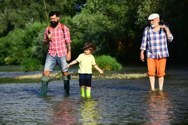 Generazione familiare e concetto di persone. Ragazzo con padre e nonno pesca a mosca all'aperto su sfondo fiume . — Foto Stock