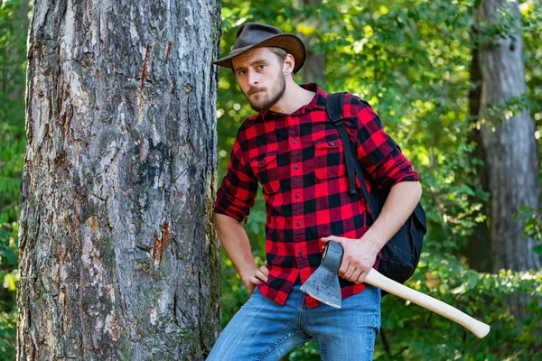 Lumberjack med yxa i hans händer. Skogshuggare som arbetar i en skog. Vilar efter hårt arbete. Skogshugg med yxa i sommar skogen. — Stockfoto