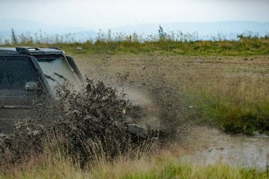 Çamurlu bir yol ile kırsal bir manzara yakın tekerlek. Çamur çukurundan çıkan off road aracı tehlike.