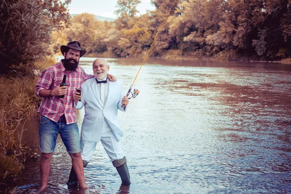 Рыбаки с удочкой на реке. Рыбалка на муху. Мужчины рыбачат в реке в летний день. Семья и поколение - летние каникулы и концепция людей . — стоковое фото