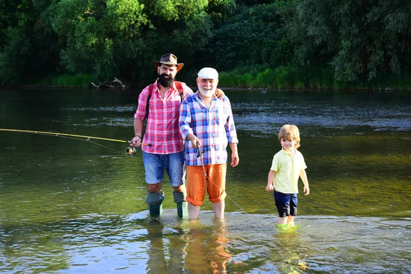 Pesca. Ragazzino pesca a mosca su un lago con il padre e il nonno . — Foto Stock