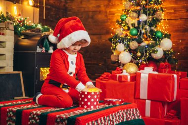 Çocuk sevimli çocuk neşeli ruh hali noel ağacı yakınında oyun. Neşeli ve parlak Noeller. Güzel bebek noel keyfini çıkarın. Çocukluk anıları. Noel baba çocuk küçük çocuk evde Noel kutlamak. Aile tatili