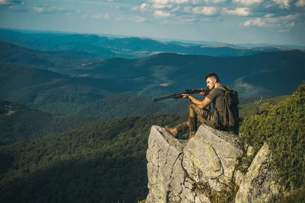 Chasseur séduisant tenant une arme et marchant dans la forêt. Un homme armé. Période de chasse saison estivale. Repérez. La chasse en montagne. Chasseur avec fusil de chasse après une chasse . — Photo