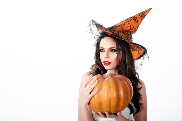Halloween heks met een gesneden pompoen - geïsoleerd op witte achtergrond. Emotionele jonge vrouw in Halloween kostuum. Halloween feest meisje. — Stockfoto