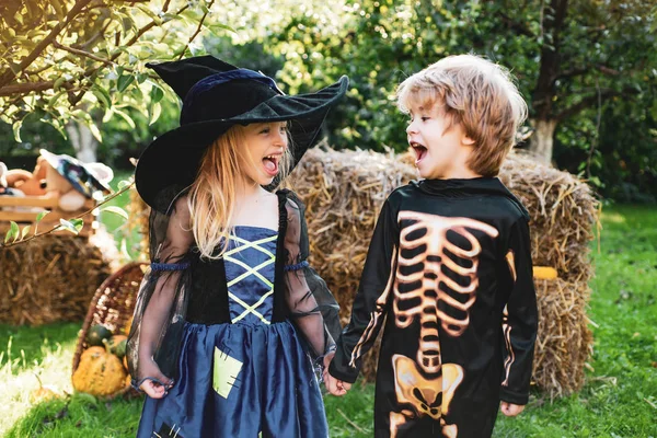 Sevimli çocuk kızı ve oğlu bir kabak ile komik yüzler yapma. Cadılar Bayramı çocuklar alanında sonbahar parkı zevk. Kırsal kesimde Cadılar Bayramı. — Stok fotoğraf