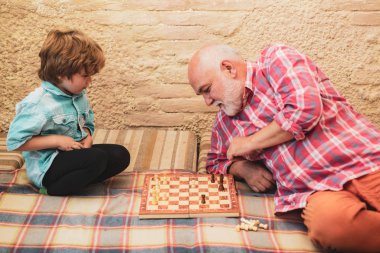 Nesil. Torununa satranç oynamayı öğreten kıdemli adam. Satranç oynayan sevimli küçük çocuk. Çetin. Mat.