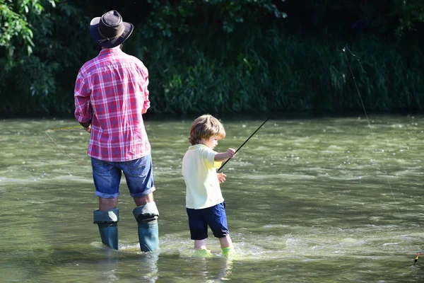 Father and son fishing. Fly fishing for trout. Happy man family concept - fishing and have fun together.