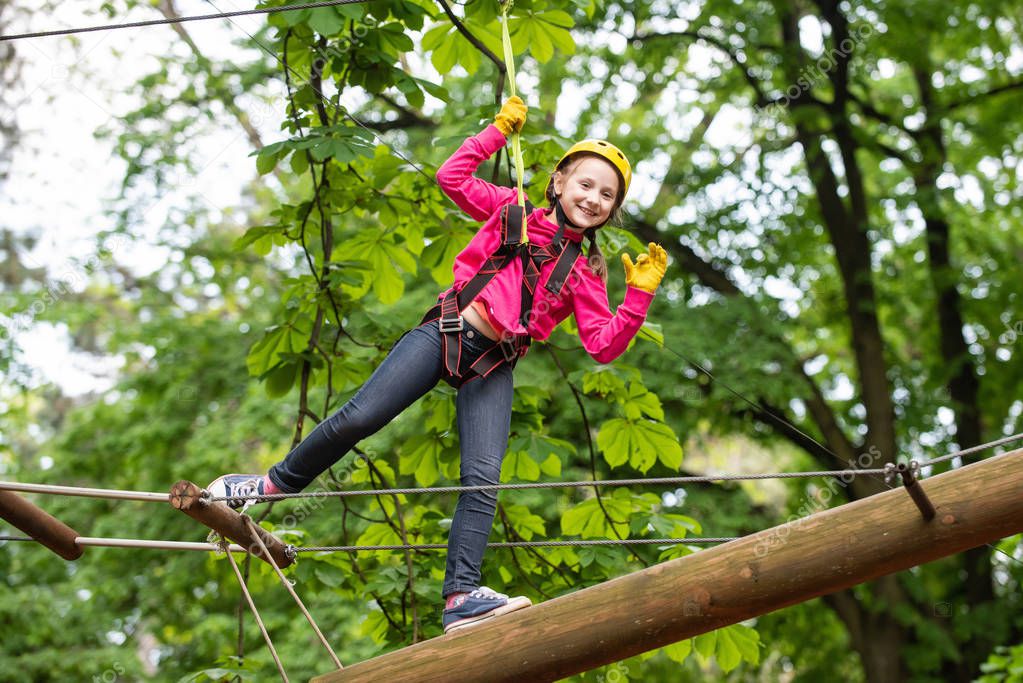 Happy little child climbing on a rope playground outdoor. Carefree childhood. Active children. High ropes walk. Child concept. Hike and kids concept.