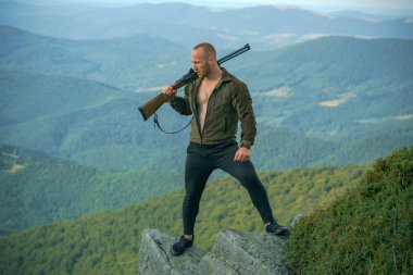 Yaz ormanında av tüfeği avlanan bir avcı. Silahlı adam avcısı. Rusya'da avcılık. Lazer görüşlü Avcı Hedef. Açık havada aktif yaşam tarzı.