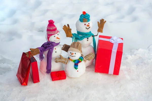 Muñeco de nieve de Navidad con bolsa de compras y regalo de Navidad. Saludo a la familia muñeco de nieve, concepto de paternidad. Muñeco de nieve con bolsa de compras y regalo en el fondo blanco de nieve . —  Fotos de Stock