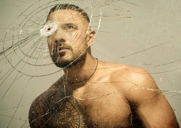 Power and vitality. Latino man full of power and energy looking through broken glass. Strong hispanic guy training power and endurance. Developing of muscular power and strength — Stock Photo, Image