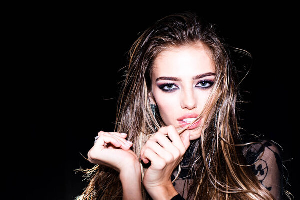 Face of a beautiful girl with smoky eyes makeup posing at studio over dark background. Fashion concept. High quality image. Fashion woman in trendy party dress.