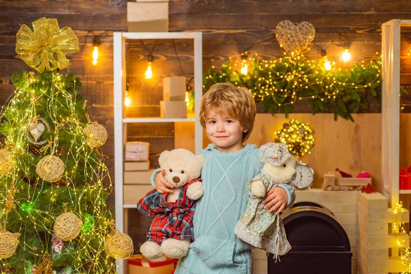 テディベアでクリスマスを祝うかわいい子供たち。カメラを見ておもちゃテディベアとサンタの子供の肖像画。新年明けましておめでとう. — ストック写真