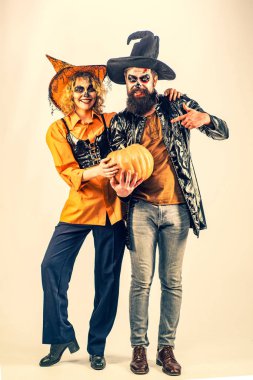 Balkabağı ile tam uzunlukta Halloween çift mutlu Cadılar Bayramı kutluyor. Balkabağı ile poz veren çift.