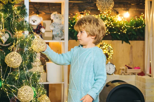 クリスマスツリーを飾る子供。子供はクリスマスの内部の背景の上に泡を保持し、泡でクリスマスツリーを飾る-新年の伝統. — ストック写真