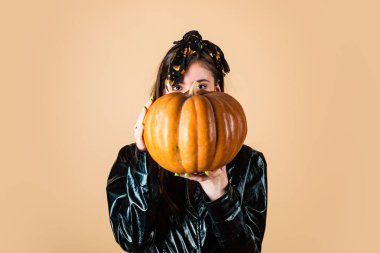 Büyük gözlü güzellik cadılar bayramı cadısı. Balkabağı olan Genç Güzel Kadın. Güzellik Kadın halloween afiş için Portre yüz. Sarı arka plan yalıtılmış.