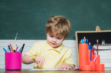 Kitap ile Mutlu sevimli akıllı çocuk ve sevimli küçük kız. Kitaplı çocuk. Çocuk tahta arka planda sınıfta öğreniyor.