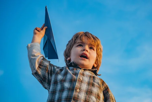 自然の中で夏におもちゃの飛行機で草原を走る幸せな子供の男の子。おもちゃの飛行機で遊んでいる小さなかわいい男の子。幸せな子供時代。小さな子供の男の子が遊んでいると雲の上を飛ぶの夢. — ストック写真