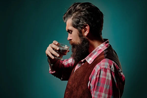 Homme barman avec barbe tient verre brandy. Boisson alcoolisée de luxe . — Photo