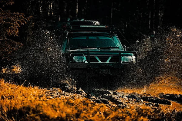 Off road sport truck between mountains landscape. Expedition offroader. Off-road vehicle goes on mountain way. Best Off Road Vehicles. Mud and water splash in off-road racing. — Stock Photo, Image