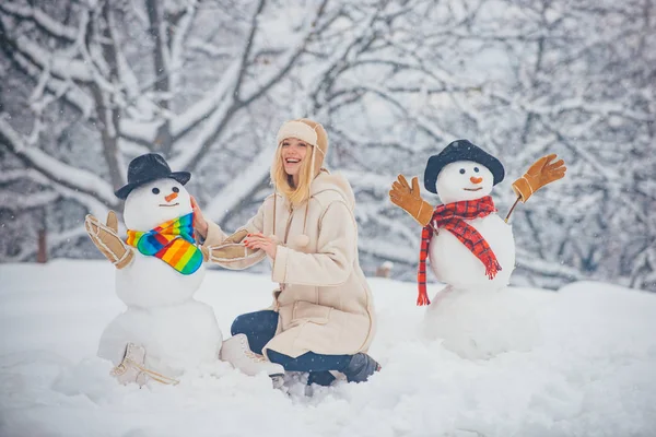 Menina engraçada do Papai Noel posando no inverno. Menina brincando com boneco de neve no parque de inverno. Feliz Natal e Boas Festas. Fazendo boneco de neve e inverno divertido para a menina . — Fotografia de Stock