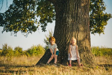 Kırsal kesimde çocukluk. Mutlu küçük çiftçiler sahada eğleniyor. Ekoloji kavramı çocuk. Eko yaşam. Çiftlikte bahar zamanı. Sevimli küçük çocuklar çiftlikte zevk. Kaygısız çocukluk.