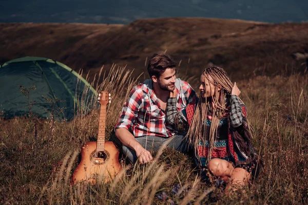 山の上に無料の代替休暇キャンプで外で抱きしめるピクニックで感情的な幸せな若い愛情のカップル. — ストック写真