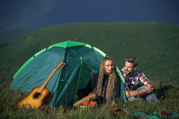 Ο ταξιδευτής και η γυναίκα έχουν ένα ωραίο χρόνο ανάπαυσης στα βουνά. Ενεργός τρόπος ζωής, χαρούμενη διάθεση και καθαρή αντίληψη του μυαλού. — Φωτογραφία Αρχείου