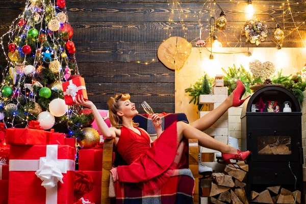 Jonge vrouw in elegante rode jurk over Kerstmis interieur achtergrond. Mooi meisje dragen in rode kerst jurk. — Stockfoto