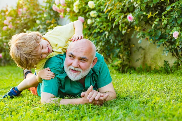 Criança com sonhos de avô no verão na natureza. Criança feliz com o avô brincando ao ar livre. Avô aposentado. Avô e filho. Responsável pela reforma . — Fotografia de Stock