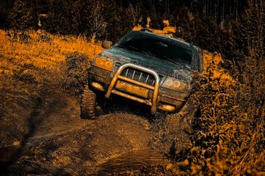 Dağ yolunda off-road seyahat. Çamur, ıslak çamur veya kil bir alanda off-road olduğunu. Çamur çukurundan çıkan offroad aracı tehlike. Off-road araç dağa gidiyor.