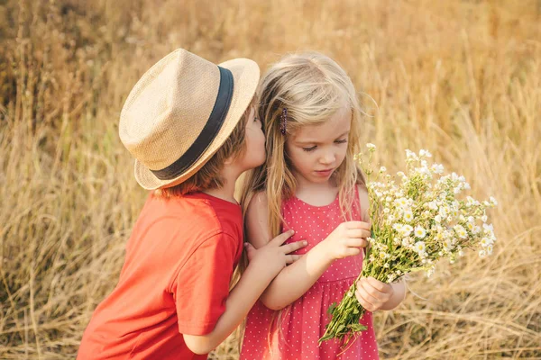 Mutlu Çocuk yaz sahasında. Mutlu çocuklar yazın doğada çayırda sarılır. İnsani duygular, çocukların ilk aşkı. Aşık küçük melekler. Sevgililer Günü. — Stok fotoğraf