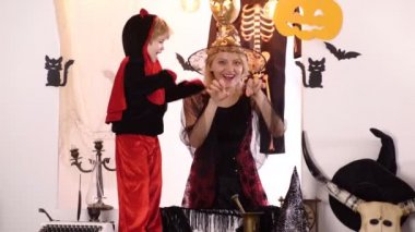 Cadı kostümlü anne ve oğlu. Yanan mumlar ile Halloween kabak baş jack fener. Mutlu Cadılar Bayramı için Büyü Sırları. Cadılar Bayramı kutlama konsepti. Cadılar Bayramı anne ve oğlu