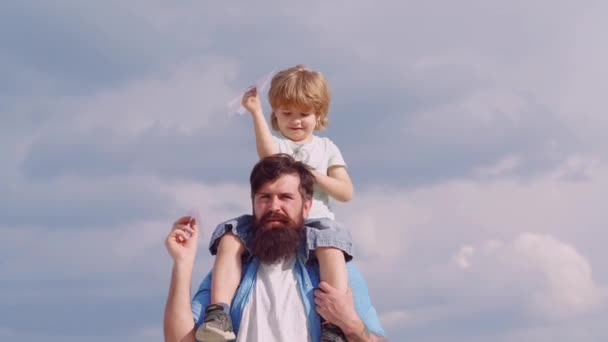 Feliz padre e hijo en el prado en verano. Aviador piloto infantil con sueños de avión de viajar. Concepto del Día del Padre. feliz padre dando hijo a cuestas paseo en sus hombros en el cielo fondo . — Vídeo de stock