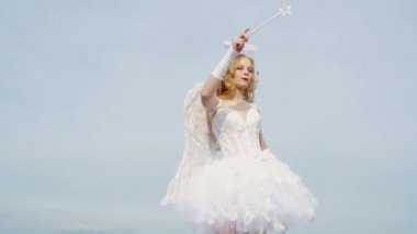 Bulut üzerinde Sevimli genç cupid - gökyüzü arka plan. Kıvırcık sarı saçlı melek çocuk kız. Bir yay ve ok St Sevgililer günü tebrik ile cupid olarak Pretty beyaz küçük kız.