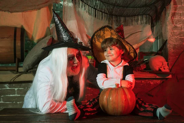 Retrato de familia divertida durante Halloween. Los hombres y los niños asustan a los invitados. Feliz familia padre e hijo en trajes en una celebración de Halloween . —  Fotos de Stock