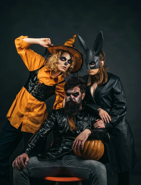 Amigos felices celebrando Halloween. Primer retrato de Halloween de grupo divertido. Sorprendido grupo de amigos en sombrero de bruja y traje . —  Fotos de Stock