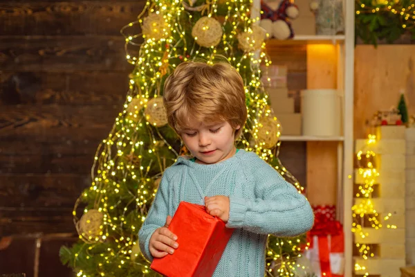 Noel hediyeli mutlu çocuk. Yeni yıl çocukları. Yeni yıl konsepti. Ahşap ev arka planında Noel hediyesi olan çocuk. — Stok fotoğraf