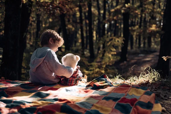 Gyermek ölelés maci ősszel vidéken. Boldog kisfiú birtoklás móka-ra mező. Gyermek koncepció. Kisfiú élvezni gyermekkori évek. — Stock Fotó