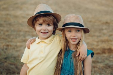 Mutlu sevimli çocuğun yaz portresi. Mutlu çocuk çiftçiler bahar alanında eğleniyor. Küçük aile çiftçileri. Eko çiftlik.