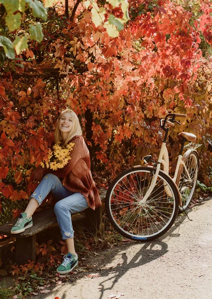 Outono prazeres simples. Lazer ativo e estilo de vida. Menina andar de bicicleta para se divertir. Loira desfrutar de relaxar parque. Buquê de outono. Outono quente. Menina com bicicleta e flores. Mulher bicicleta outono jardim — Fotografia de Stock