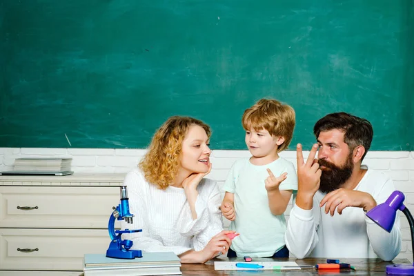 Young happy family schooling math together. Education. Woman and man helps the child boy. Happy family. School community partnership models.