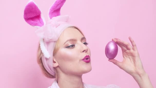 sexy Pin Up Frau mit Maske Osterhase auf rosa Hintergrund und sieht sehr sinnlich aus. Eiersuche und Eierbemalen. Hasen-Retro-Mädchen. Bunny Pin Up Frau - Nahaufnahme.