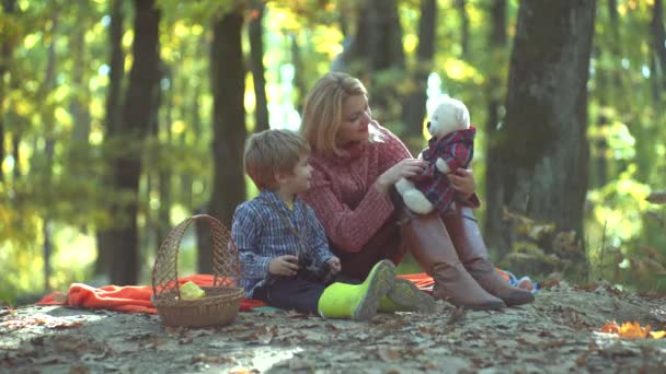 Mor och barn son ha roligt och spela på höst natur. Ung förälder och barn som har picknick och koppla av tillsammans på höstnar solig dag. — Stockvideo