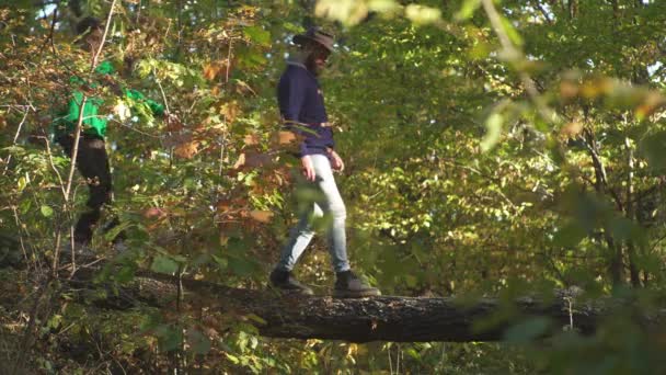 Lyckligt par klättring och ha kul i skogen. Utomhus höst atmosfäriska stunder och dröm. Aktiva personer. Hej höst. Vandrings koncept. Par vandring i parken. — Stockvideo