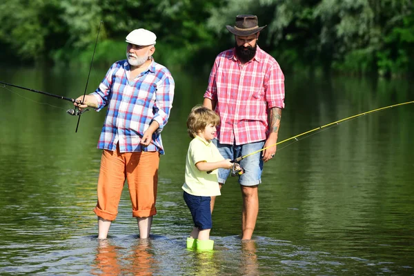 Nonno con figlio e nipote che si divertono nel fiume. Padre, figlio e nonno in battuta di pesca. Uomini hobby . — Foto Stock