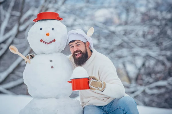 Chef de Noël. Homme avec bonhomme de neige dans la cuisine d'hiver. Beau Père Noël cuisinier . — Photo