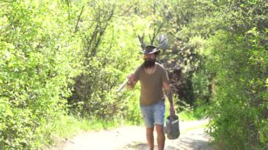 Çiftlikte duygusal komik sakallı hipster. Adam çiftçi kavramı. Bahar tarlasında eğlenen mutlu çiftçi. Bahar tarlasında spud ile çalışan yakışıklı sakallı çiftçi.