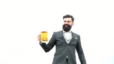 Siyah takım elbiseli şık yakışıklı adam gökyüzü arka plan üzerinde bira içiyor. Sakallı adam bira içiyor. Kutlama oktoberfest festival konsepti.